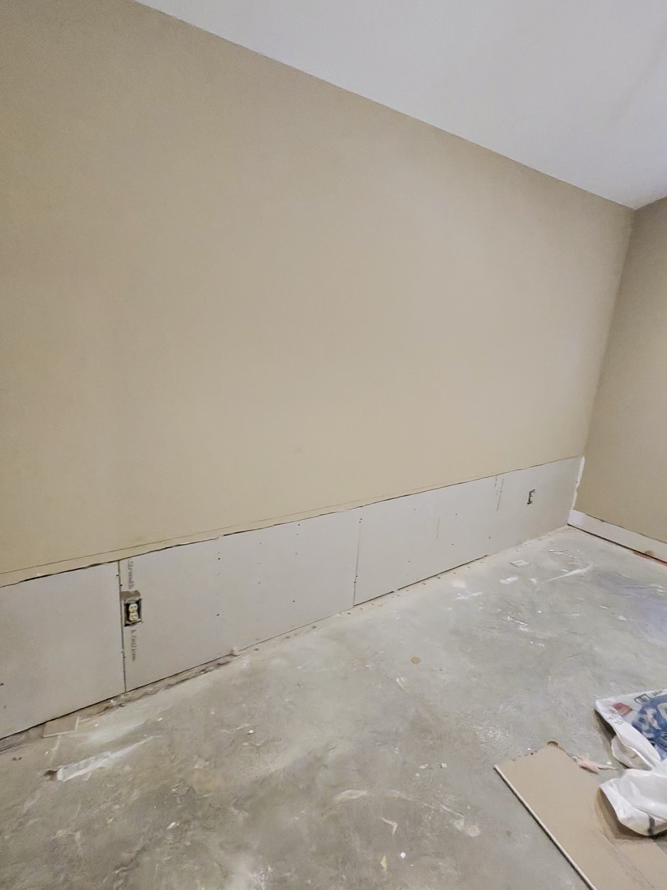 New drywall installed along the lower wall during repair