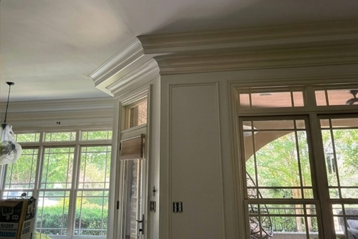 A smooth finished ceiling with recessed lighting and crown moulding