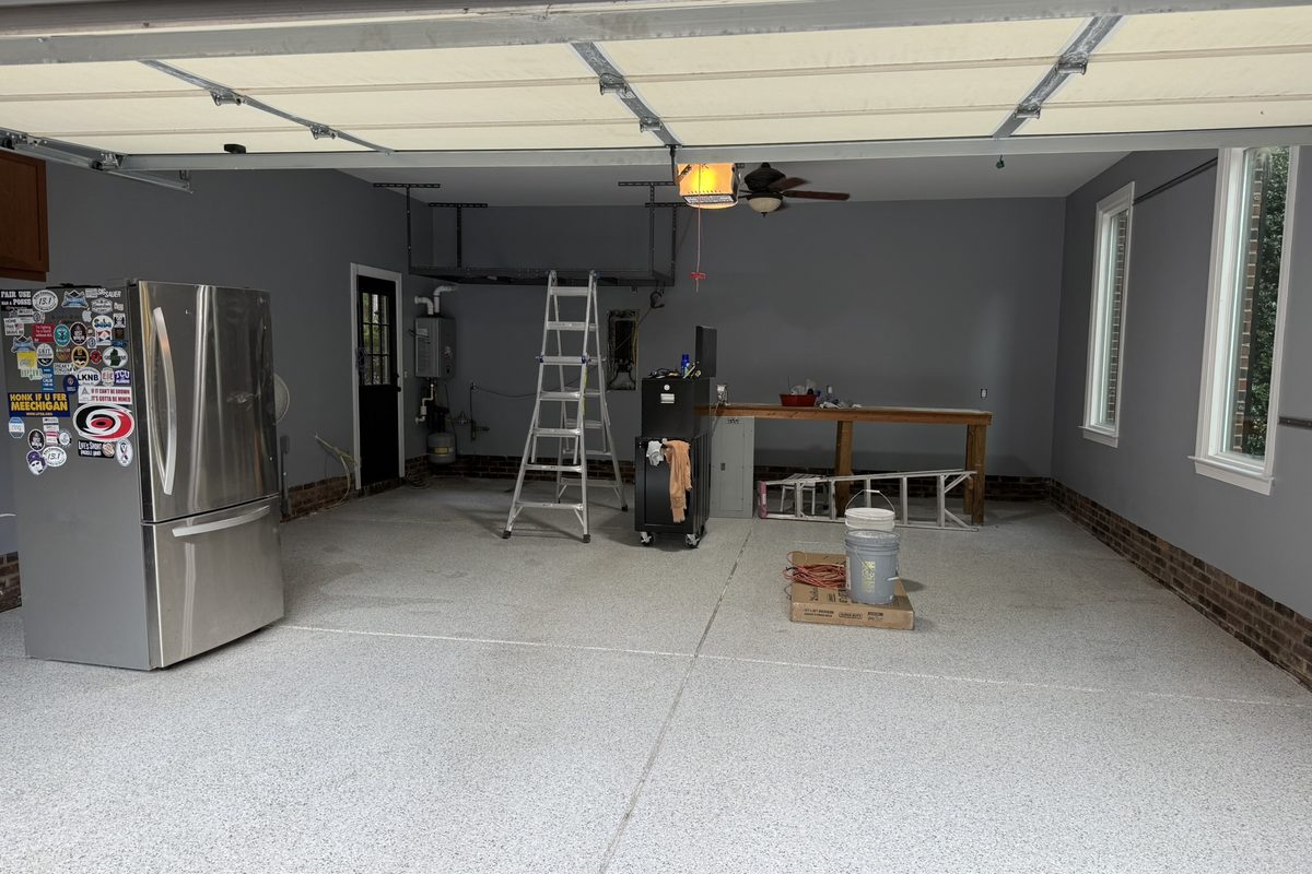 A finished garage with grey painted walls and a speckled epoxy floor