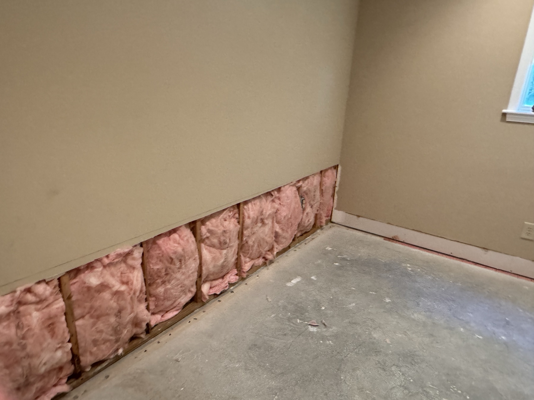 Water-damaged lower wall before drywall repair in Charlotte, NC